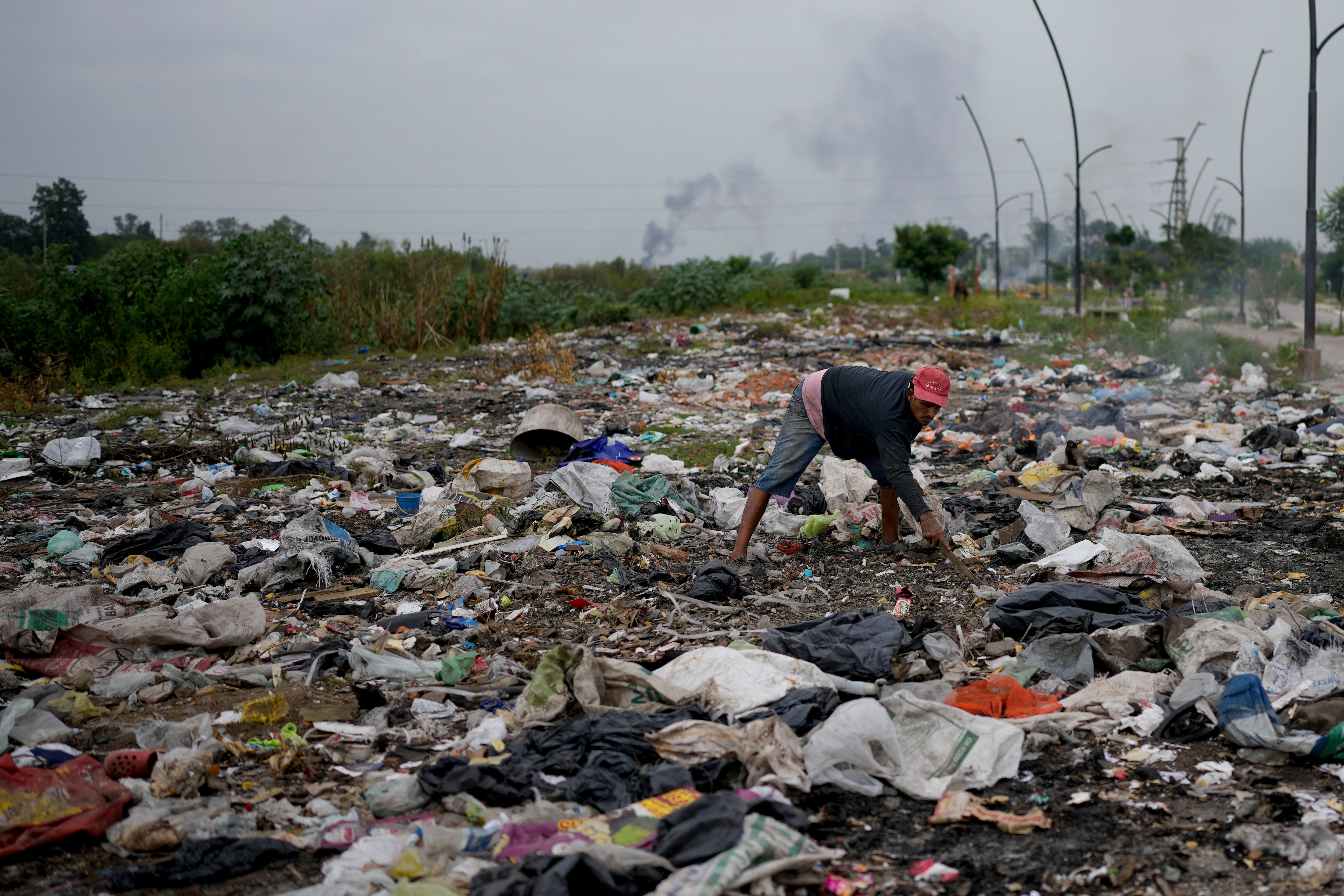 Un hombre busca en la basura algo útil en Tucumán, Argentina, el jueves 30 de marzo de 2023.(AP Foto/Natacha Pisarenko)