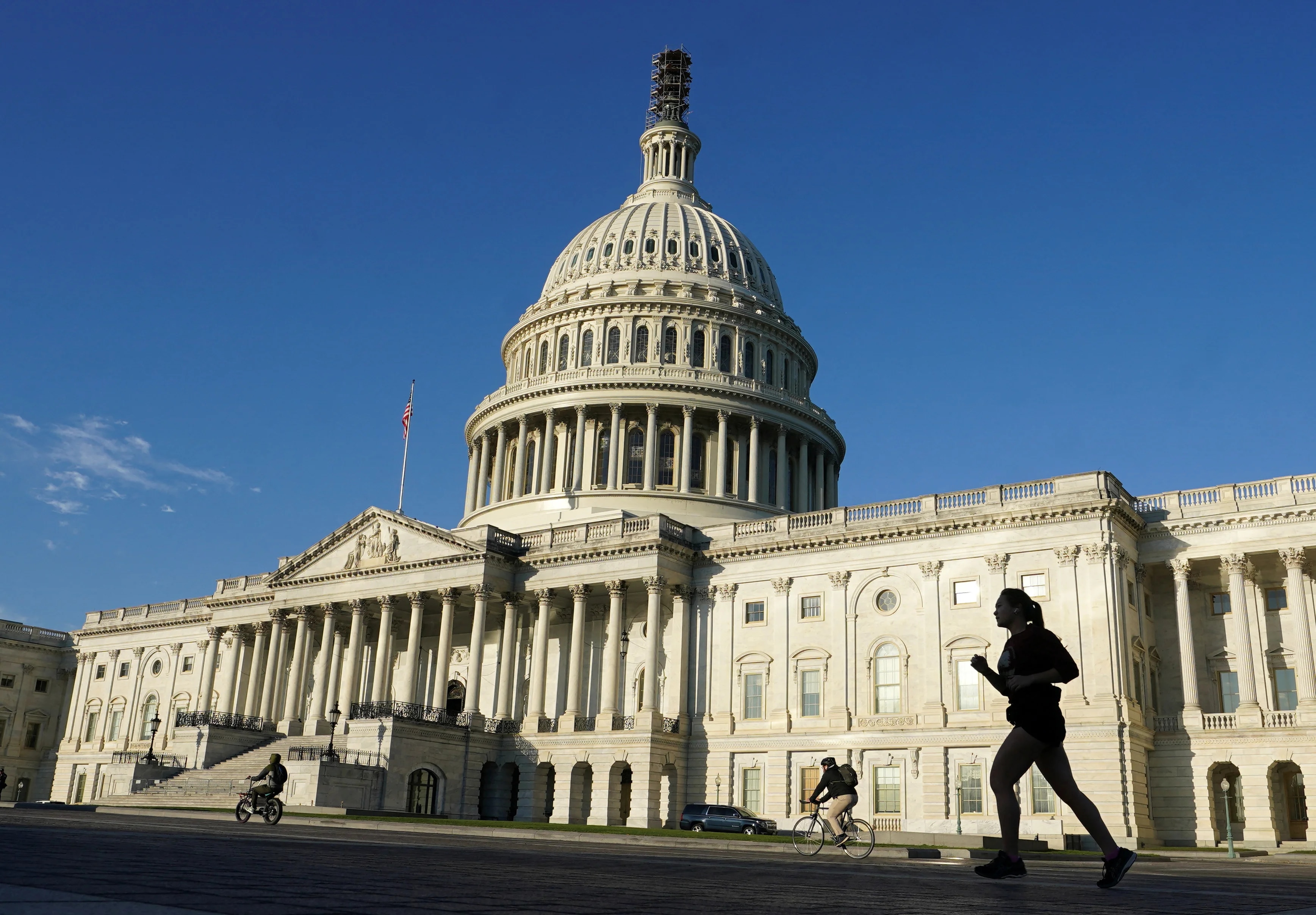 A jogger passes in front of the Capitol, where today House Republicans will continue proceedings to elect a new House speaker following last week's ouster of Kevin McCarthy at the Capitol in Washington, U.S., October 12, 2023. REUTERS/Kevin Lamarque